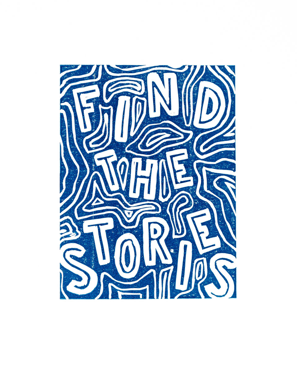 Blue linocut with hand-carved lettering reading “Find the stories”.